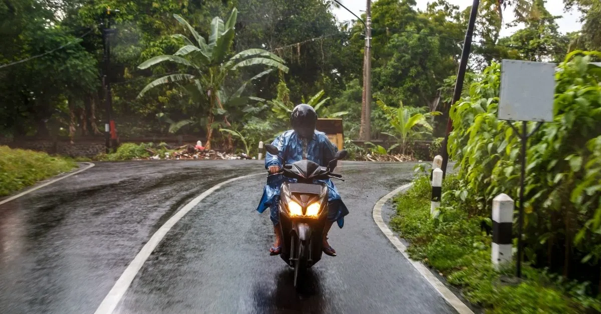 Man driving a scooter in Bali in the rain