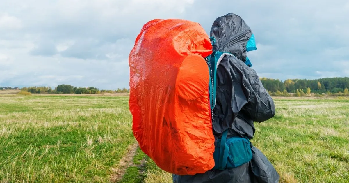 Backpacker in the rain with a backpack rain cover