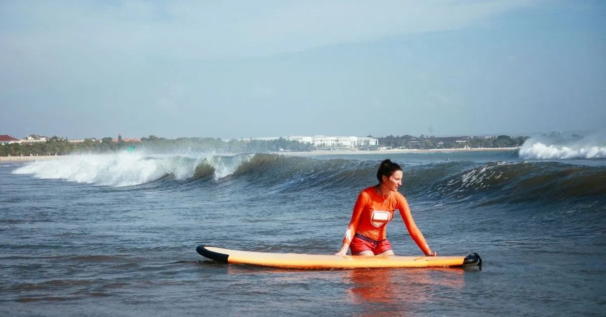 Woman learning to surf in Kuta Beach