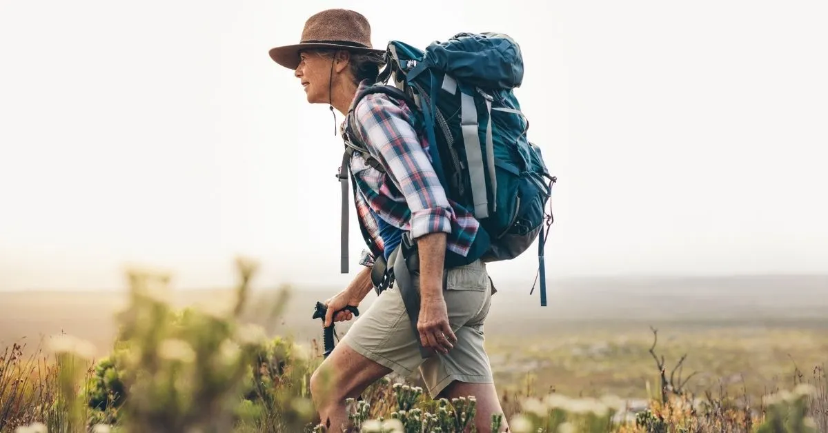 https://abrokenbackpack.com/wp-content/uploads/2022/02/Woman-with-a-hat-hiking.webp