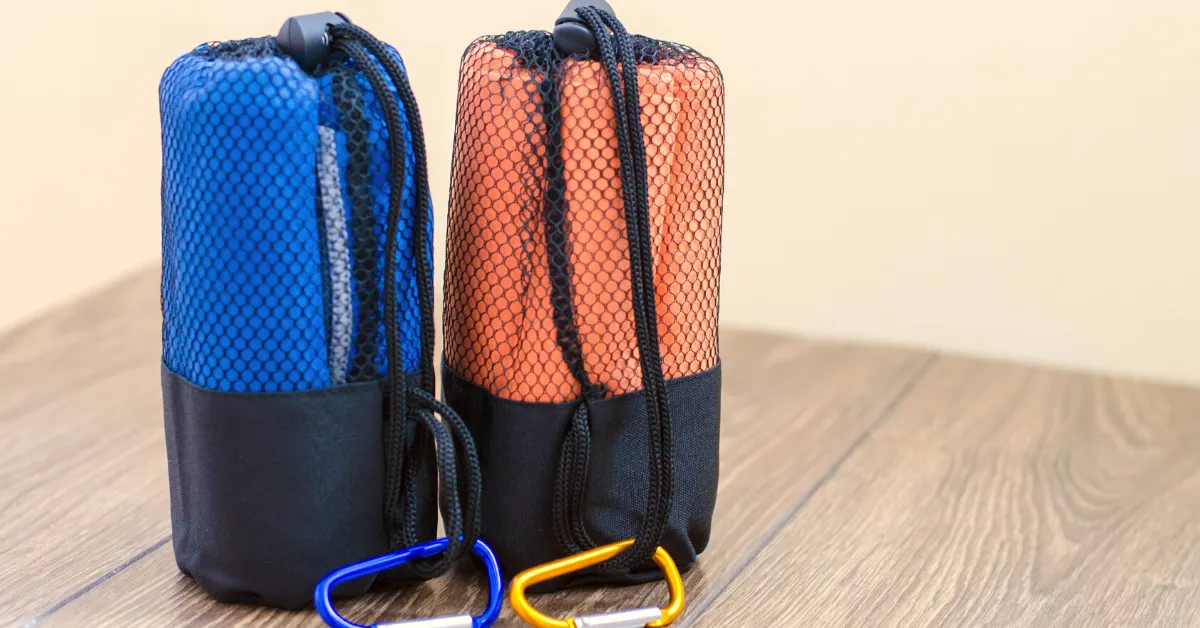 blue and red Camp towels inside rolled carrying case with carabiner