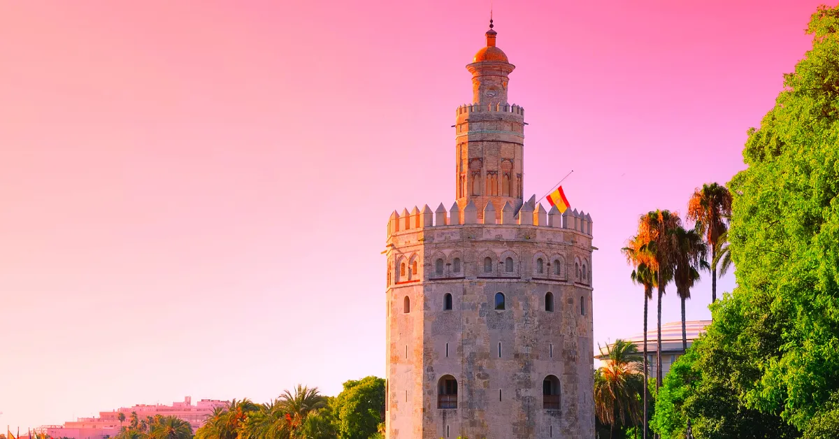 gold tower seville pink sky ssunset and palm trees
