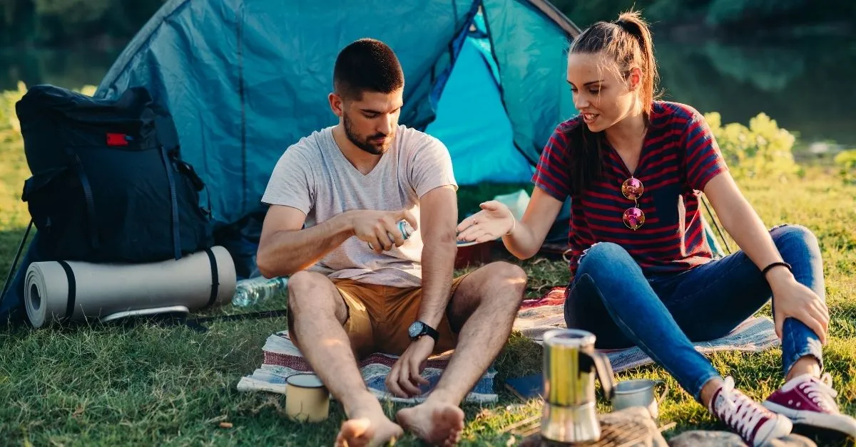 Couple trying to get rid of mosquitoes camping