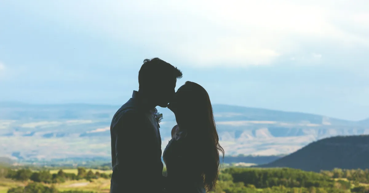 couple kissing silhouette in front of colorado mountain range