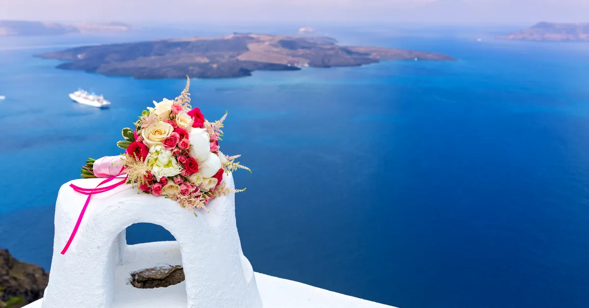 wedding flower boquet on the edge of a white building on the coast of greece