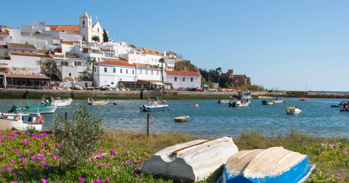 ferragudo seaside town with two small paddle boats sitting on the grass