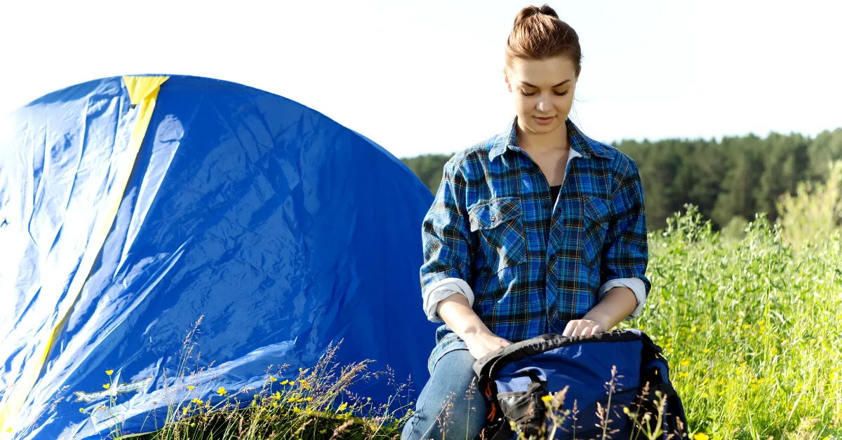 girl in front of tent in blue plaid shirt
