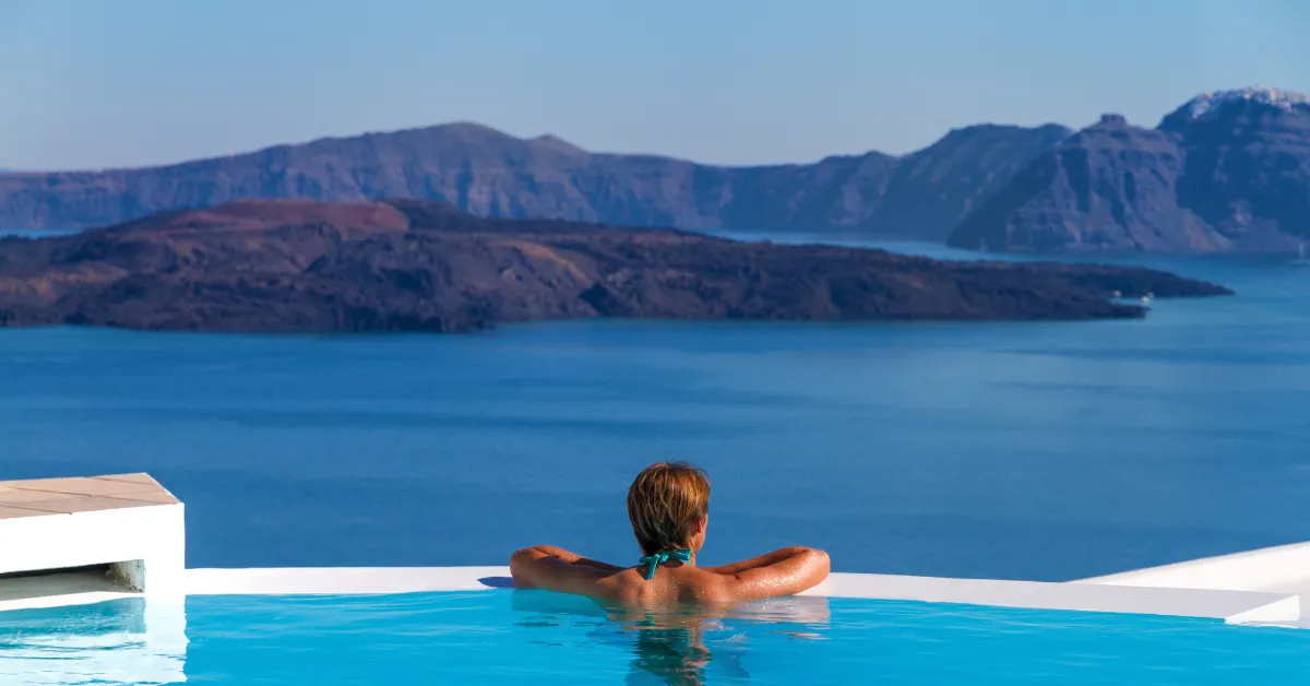 person looking out at view from santorini infinity pool