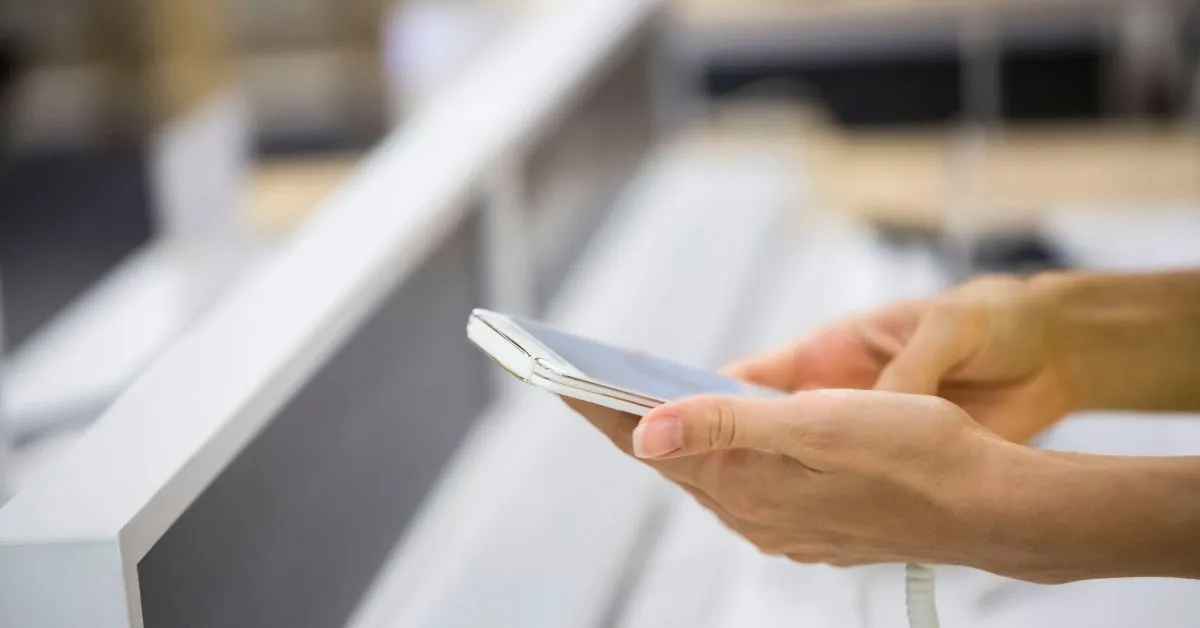 Woman inserting a sim card in her mobile phone