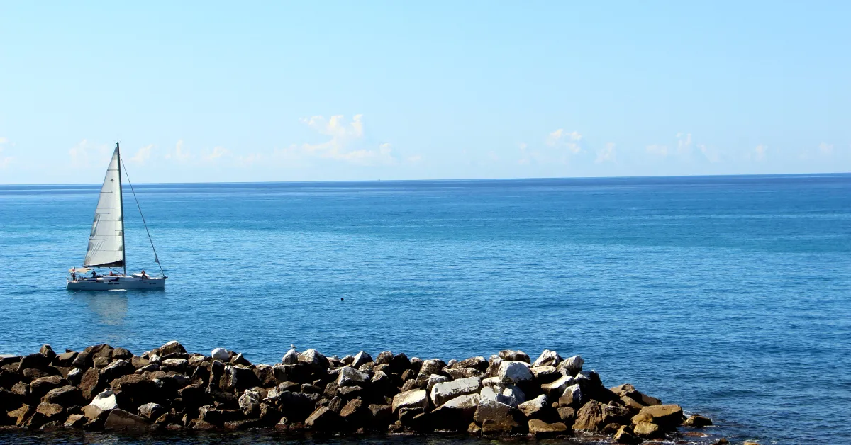 cinque terre sailboat and rocks