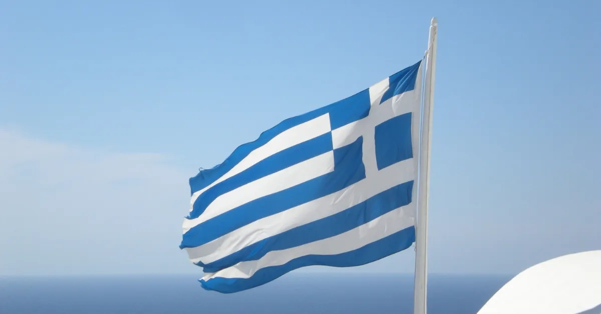 The Greek flag overlooks the coast