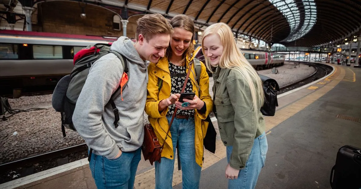 Travelers looking at a phone in a train station in Europe