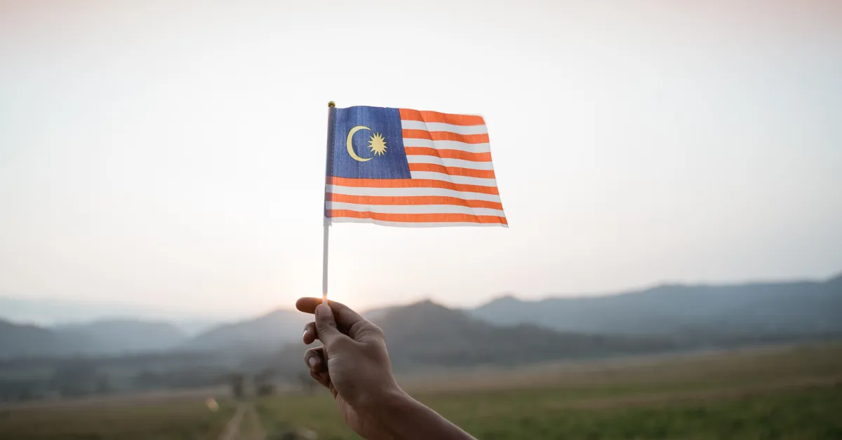hand holding malaysian flag