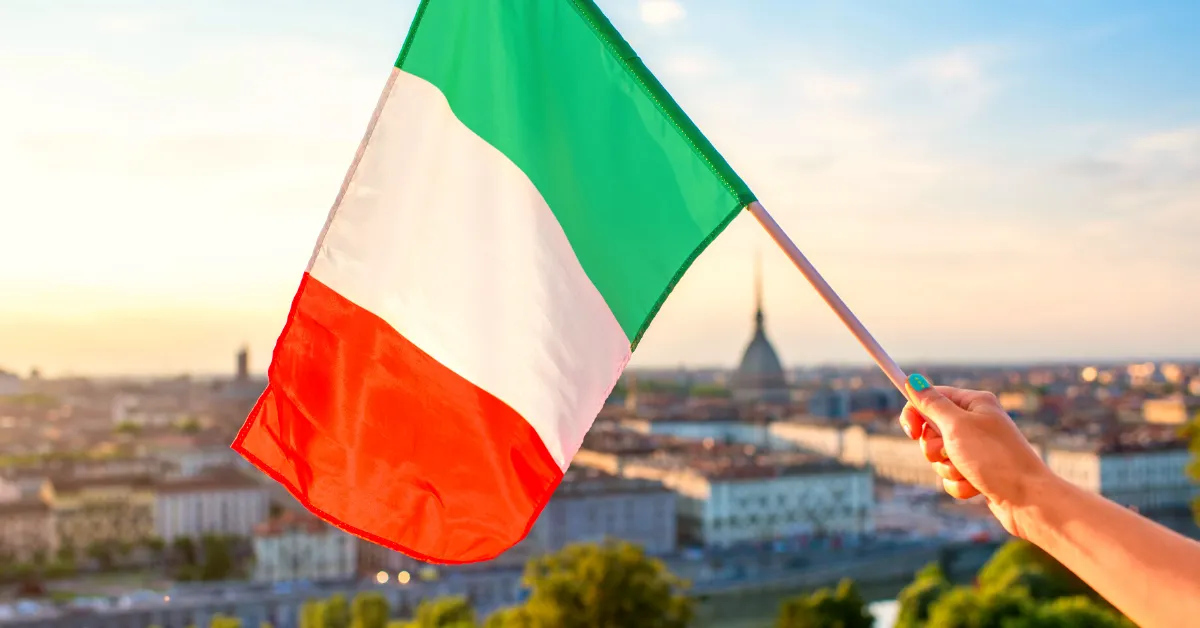 hand holding small italian flag over city