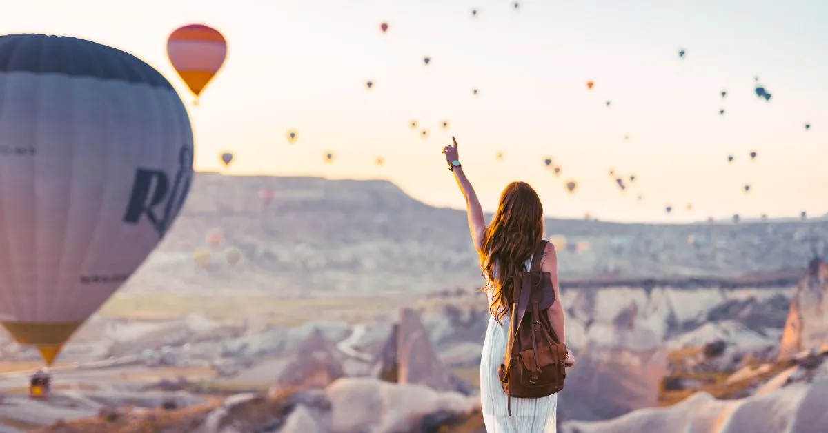 Tourist watching hot air balloons at sunrise, Cappadocia in Turkey