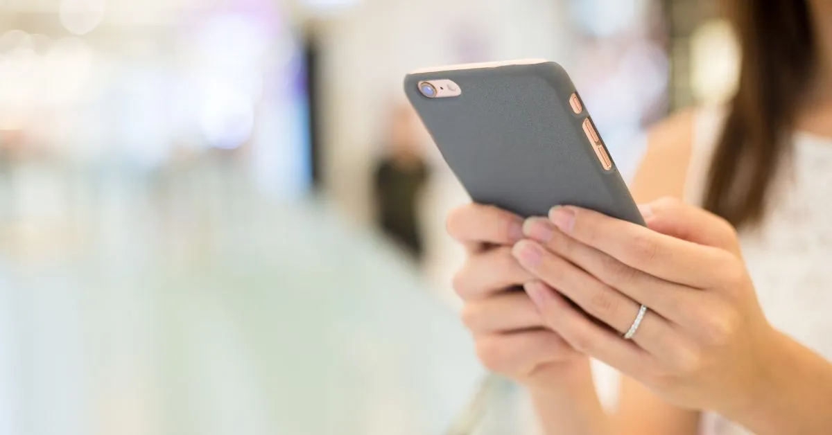 Woman with her phone in hand at the airport