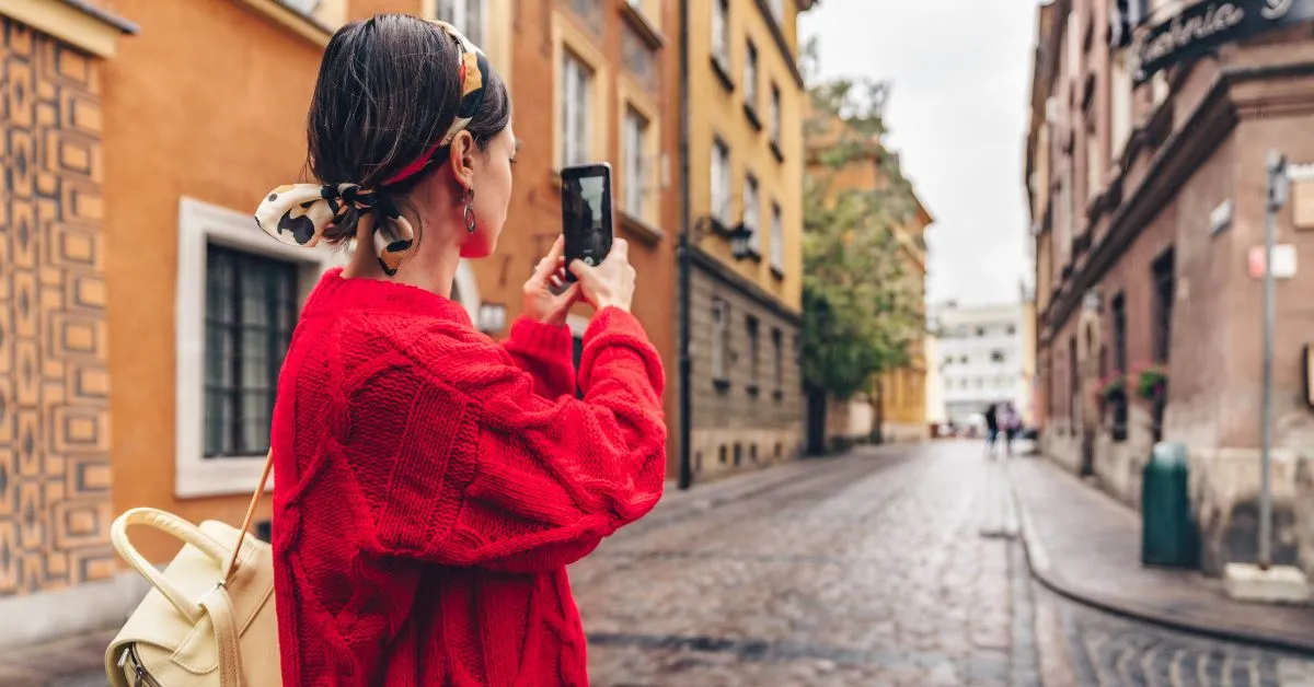 Woman traveling in Europe with a phone taking a photo
